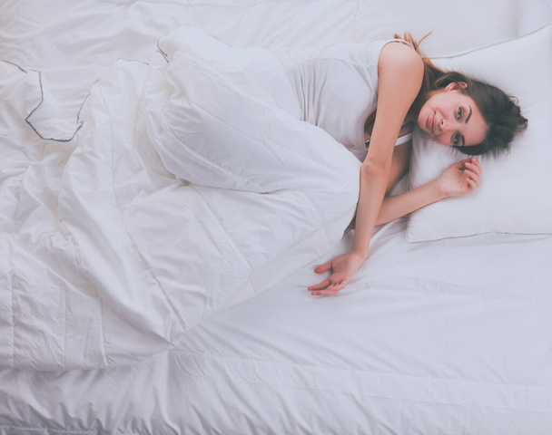 Beautiful girl sleeps in the bedroom, lying on bed. - Valokuva, kuva