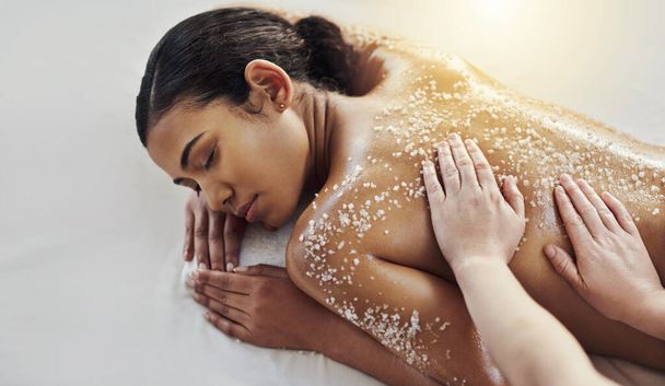 Salt can replenish tired and dry skin. a young woman getting an exfoliating massage at a spa - Fotoğraf, Görsel