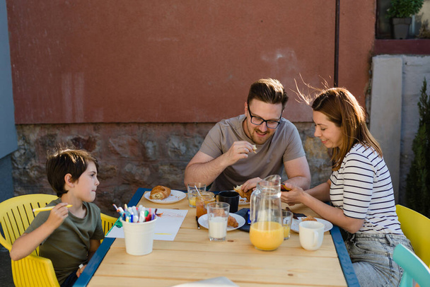 family having breakfast in backyard - Фото, изображение