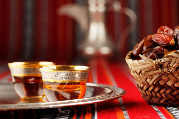Tecido abriano icônico com chá árabe e datas simbolizam hospitalidade árabe
 - Foto, Imagem