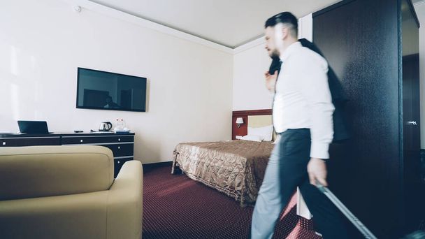 Young businessman entering hotel room after check-in. Travel, business and people concept - Foto, Bild