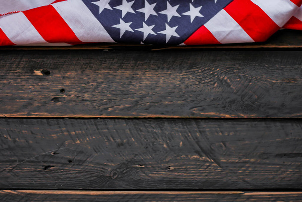 Αμερικανική σημαία τοποθετημένη σε μαύρο ξύλινο τραπέζι την Ημέρα της Αμερικανικής Ανεξαρτησίας. - Φωτογραφία, εικόνα
