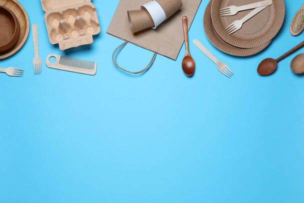 Different eco items on light blue background, flat lay with space for text. Recycling concept - 写真・画像