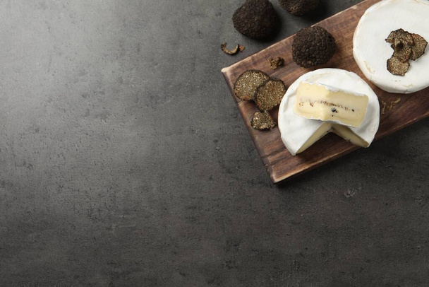 Delicious cheeses and fresh truffles on grey table, flat lay. Space for text - Fotó, kép