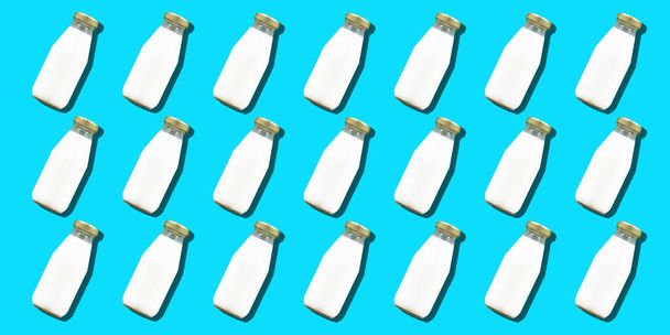Milk bottle minimal background. Many glass bottles of white cows milk or yogurt in a pattern. High quality photo - Foto, immagini