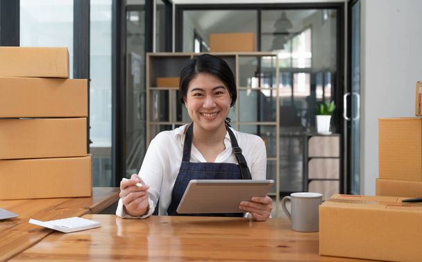 Portrait asian small business entrepreneur SME working with box at home, SME e-commerce digital technology concept - 写真・画像