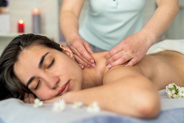 Красивая женщина получает восстановительный массаж на спине в спа-салоне. Концепция косметики - Фото, изображение