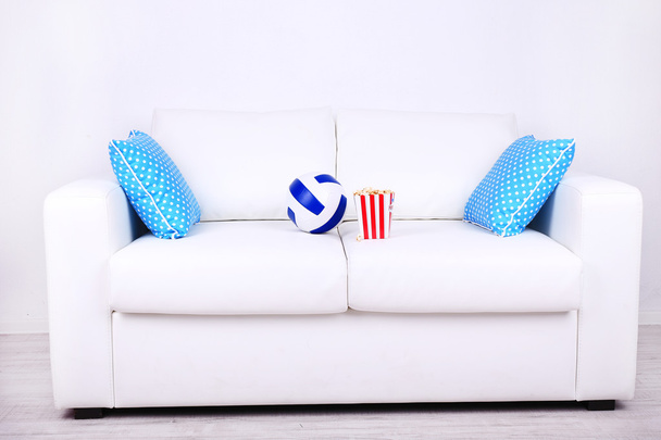 Popcorn and ball on sofa in room - Fotoğraf, Görsel