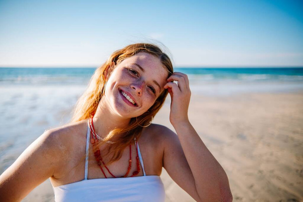A cute Blonde British lady with dimples smiling on the beach - Фото, изображение