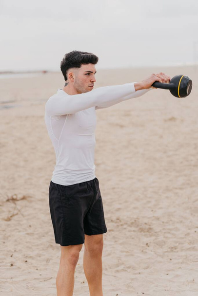Un plano vertical de un español haciendo ejercicio cerca de la playa - Foto, imagen