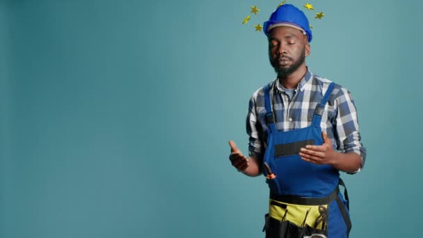 African american construction worker being dizzy and lightheaded, circle of stars above head concept. Engineer with hardhat, dizziness cartoonish style. 3d render animation. - Video