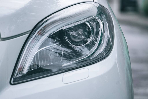 A closeup shot of a headlight of a car - Foto, Imagen