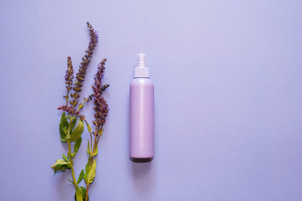 Lilac plastic bottle, dispenser, with lavender flowers on a light background. Copy space. Top view, flat lay - Fotó, kép