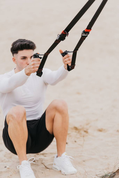 A vertical shot of a Spanish man exercising near the beach - 写真・画像