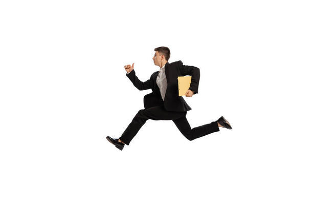 In a hurry. Creative portrait of young office worker in business suit running isolated over white background. Finance, aspiration, business, job concept. copyspace for ad - Photo, image