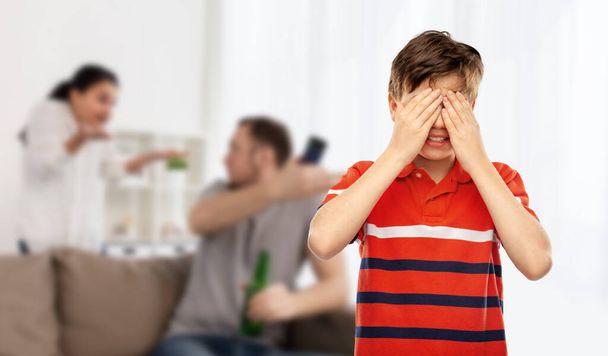 emotional abuse, family issue and violence concept - boy closing eyes with hands over parents fighting on background - Photo, Image