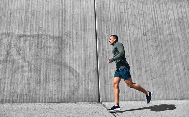 fitnesz, sport és egészséges életmód koncepció - fiatal férfi fut a szabadban - Fotó, kép