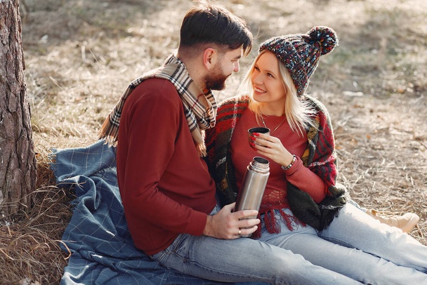 Couple by the tree. People in a spring forest. Pair with thermos. - Photo, Image