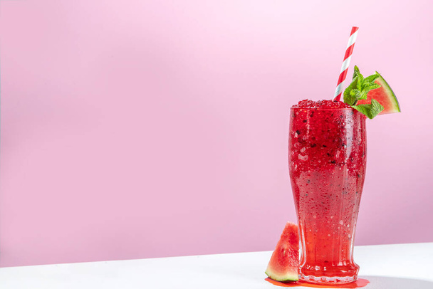 Erfrischendes kaltes Sommergetränk Wassermelone Slushie, eisgekühltes Dessertgetränk Granita, zerkleinertes Wassermeloneneis auf trendigem weiß-rosa Hintergrund Kopierraum - Foto, Bild