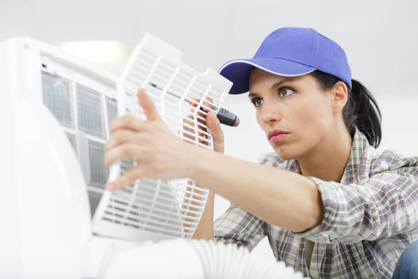 female worker repairing an air conditioner - Foto, Imagem