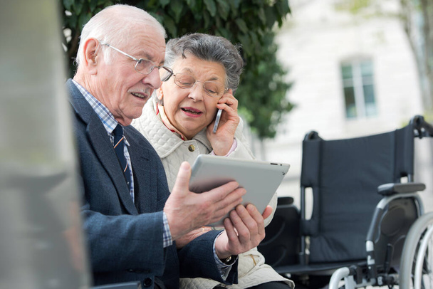 senior couple with smartphone and tablet outdoors - Zdjęcie, obraz