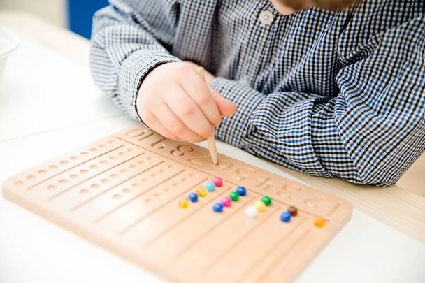 Bordo di perline Montessori. Imparare a contare e scrivere numeri, preparare il bambino per l'aritmetica mentale, sviluppare un senso di ordine, messa a fuoco, coordinamento e precisione. - Foto, immagini