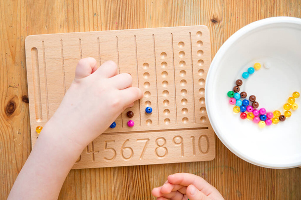 Montessori Beads Board. Learning to count and write numbers, prepare child for mental arithmetic, develop a sense of order, focus, coordination and accuracy. - Photo, Image