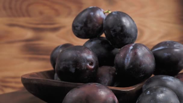 Plum on a wooden rotating cup on a wooden background. High quality 4k footage - Filmagem, Vídeo
