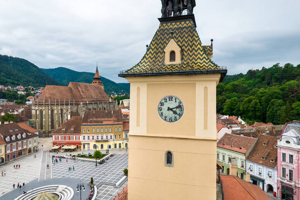 Aerial drone view of The Council Square in Brasov, Romania. Old city centre with County Museum of History, Black Church on the background, buildings, people - Foto, Imagen