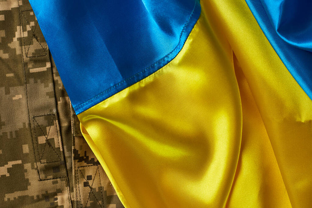 Bandera de Ucrania y uniforme militar de soldado ucraniano. Fuerzas Armadas de Ucrania - Foto, imagen