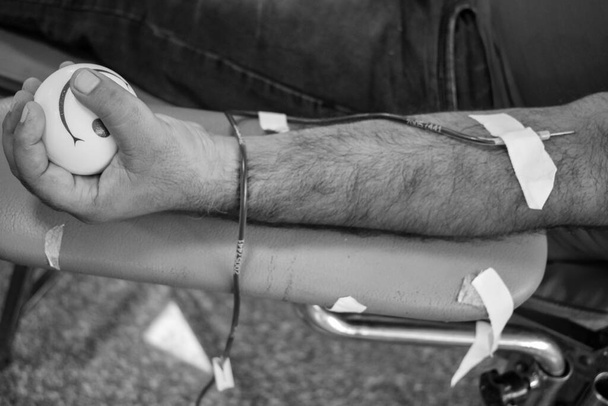 Donneur de sang au camp de don de sang tenu avec une balle pleine d'entrain tenant en main au temple Balaji, Vivek Vihar, Delhi, Inde, Image pour la journée mondiale des donneurs de sang le 14 juin de chaque année, Camp de don de sang - Photo, image