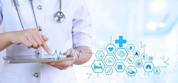 Female doctor or nurse using digital tablet with medical network interface icons on blurred hospital background, Modern medical technology concept - Photo, image
