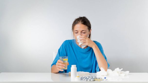 Una donna con un naso che cola e un raffreddore - trattamento per l'influenza a casa. Foto di alta qualità - Foto, immagini