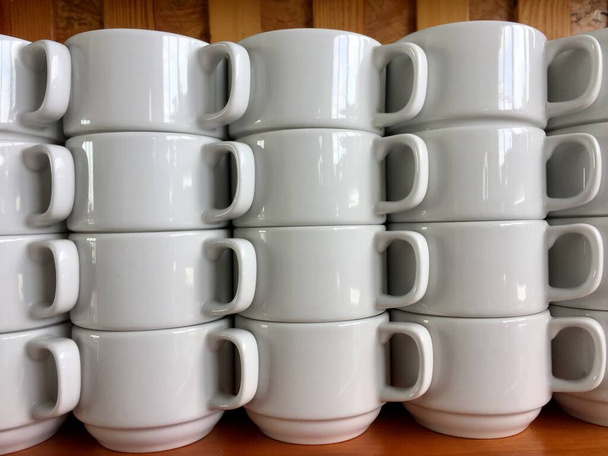  the arrangement of ceramic glasses neatly lined up on a shelf. - Photo, image