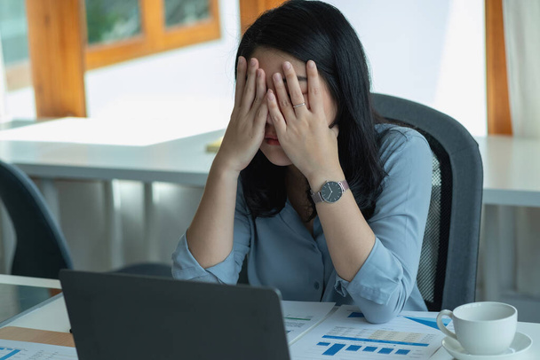 Konzept Burnout-Syndrom. Geschäftsfrau fühlt sich unwohl bei der Arbeit. Was durch Stress verursacht wird, angehäuft durch erfolglose Arbeit und weniger ruhenden Körper. Konsultieren Sie einen Fachpsychiater. - Foto, Bild