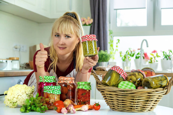 Woman jar preserve vegetables in the kitchen. Selective focus. Food. - Foto, afbeelding