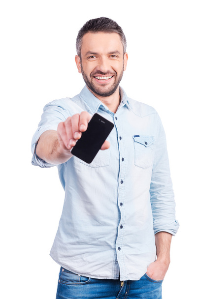 Man in casual wear showing  smart phone - Foto, afbeelding