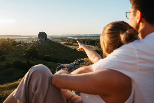 Man and Woman Enjoying Picnic with Beautiful Sunset Outdoors, Scenic Landscape and Nature Miracle Giant Stone on Background - Foto, Imagem
