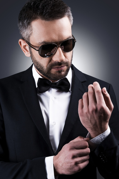Mature man in sunglasses adjusting sleeve - Foto, imagen