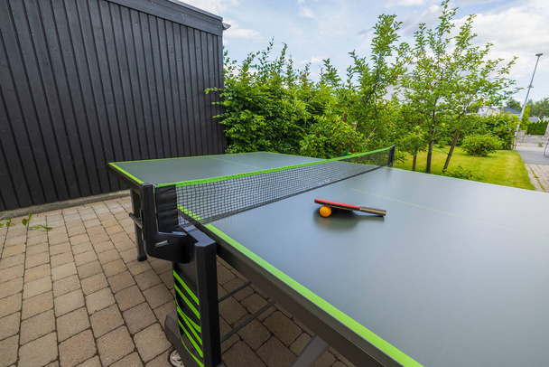 Close up view of tennis table with rackets in courtyard of private house. Sweden. - Valokuva, kuva