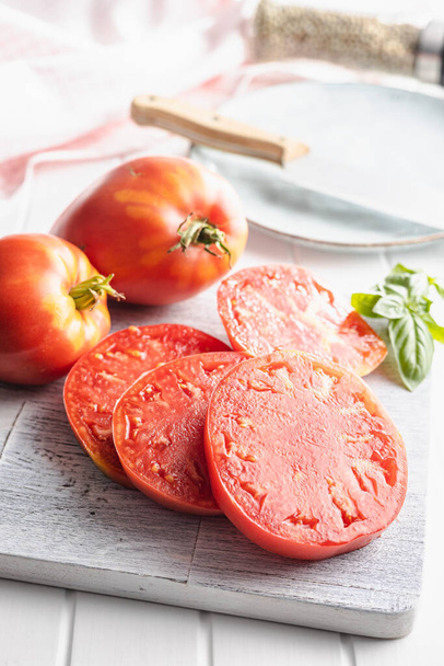 Sliced bull heart tomatoes on a cutting board. - Фото, зображення