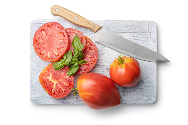 Sliced bull heart tomatoes on cutting board isolated on a white background. - Foto, Imagen