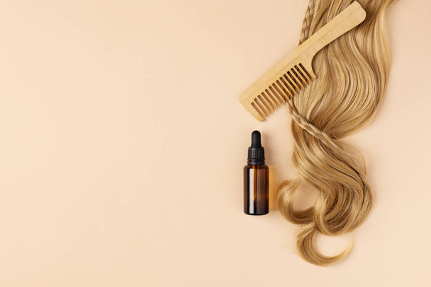 Bottle of oil for restore and recovery damaged hair. Hair curl and hair oil top view. - Fotoğraf, Görsel