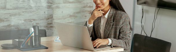 Sorrindo mulher asiática trabalhando laptop sentado na sala de reuniões no escritório. Foto de alta qualidade - Foto, Imagem