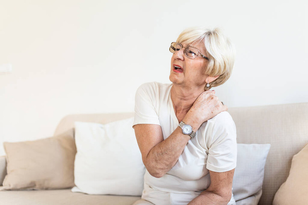 Close up of sad senior lady with neckache. Senior woman with chronic pain syndrome fibromyalgia suffering from acute neckaches. Senior woman suffering from neck pain - Fotoğraf, Görsel