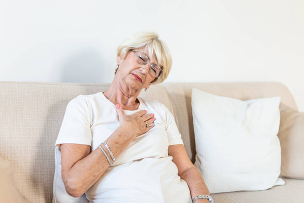 Senior woman having a pain in the heart area. Heart Attack. Chest pain. Health Care, Medical Concept. Elderly Woman having heart attack at home - 写真・画像