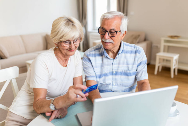 Ηλικιωμένο ζευγάρι που πληρώνει λογαριασμούς σε απευθείας σύνδεση στο lap-top - Φωτογραφία, εικόνα