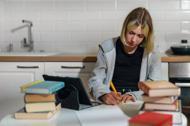 Teenage girl doing her schoolwork at home. - Foto, afbeelding