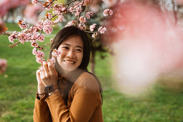 beautiful portrait of beautiful woman enjoy cherry blossom in the park - Photo, Image