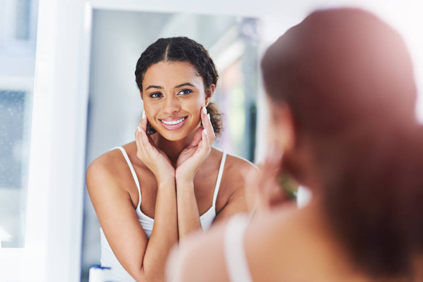 If your skin is flawless, youre flawless. an attractive young woman touching her face during her morning routine - Foto, Imagen